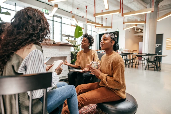 Four people seated together in an open-concept office space